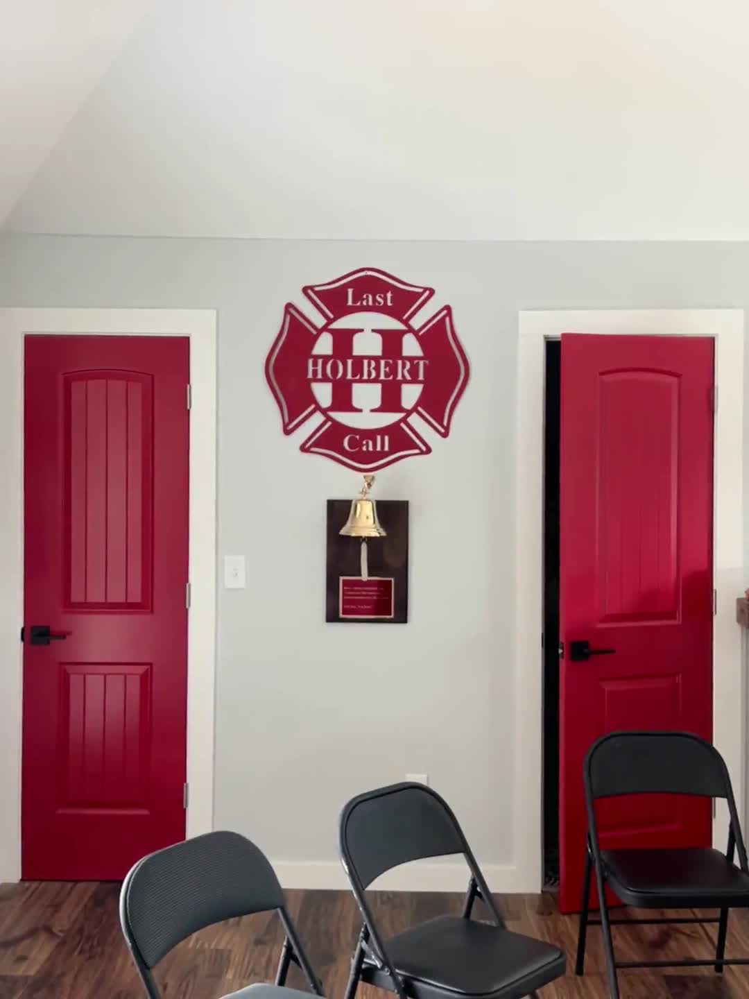 A room with red chairs and a firefighter logo on the wall, created by a Custom Home Builder.