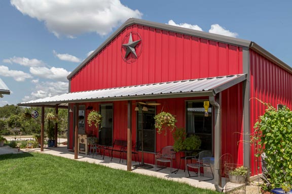 A red barn-style house with a front porch under a clear sky, recently renovated by a General Contractor in McKinney, TX.